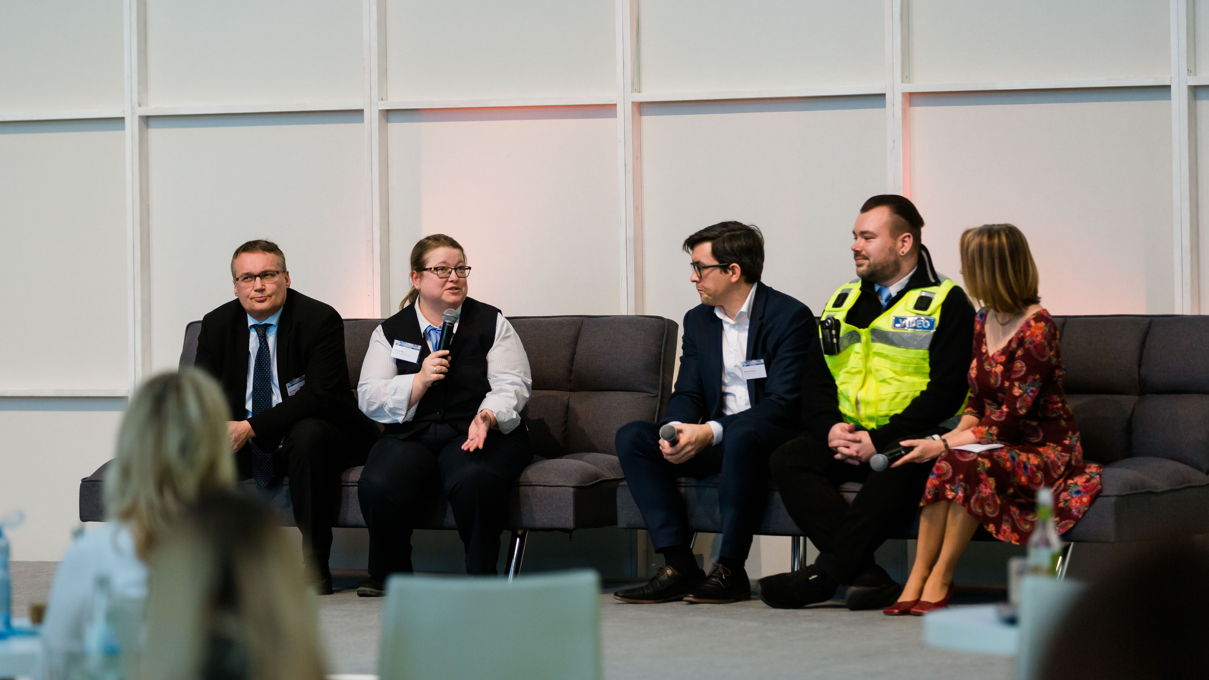 Teilnehmer einer Podiumsdiskussion reden miteinander auf der Bühne. - öffnet Bild in größerer Ansicht