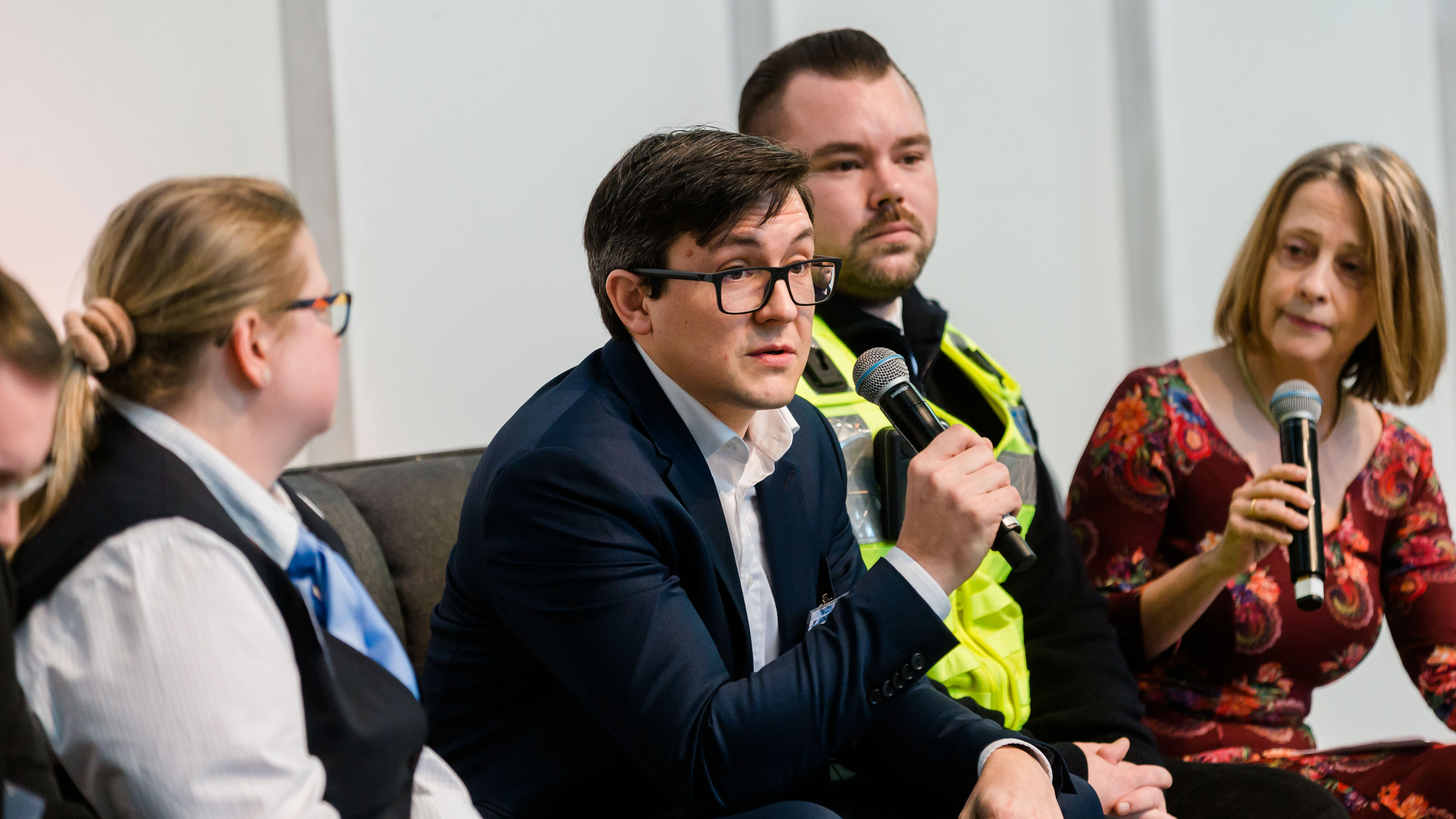 Teilnehmer einer Podiumsdiskussion reden miteinander auf der Bühne. - öffnet Bild in größerer Ansicht