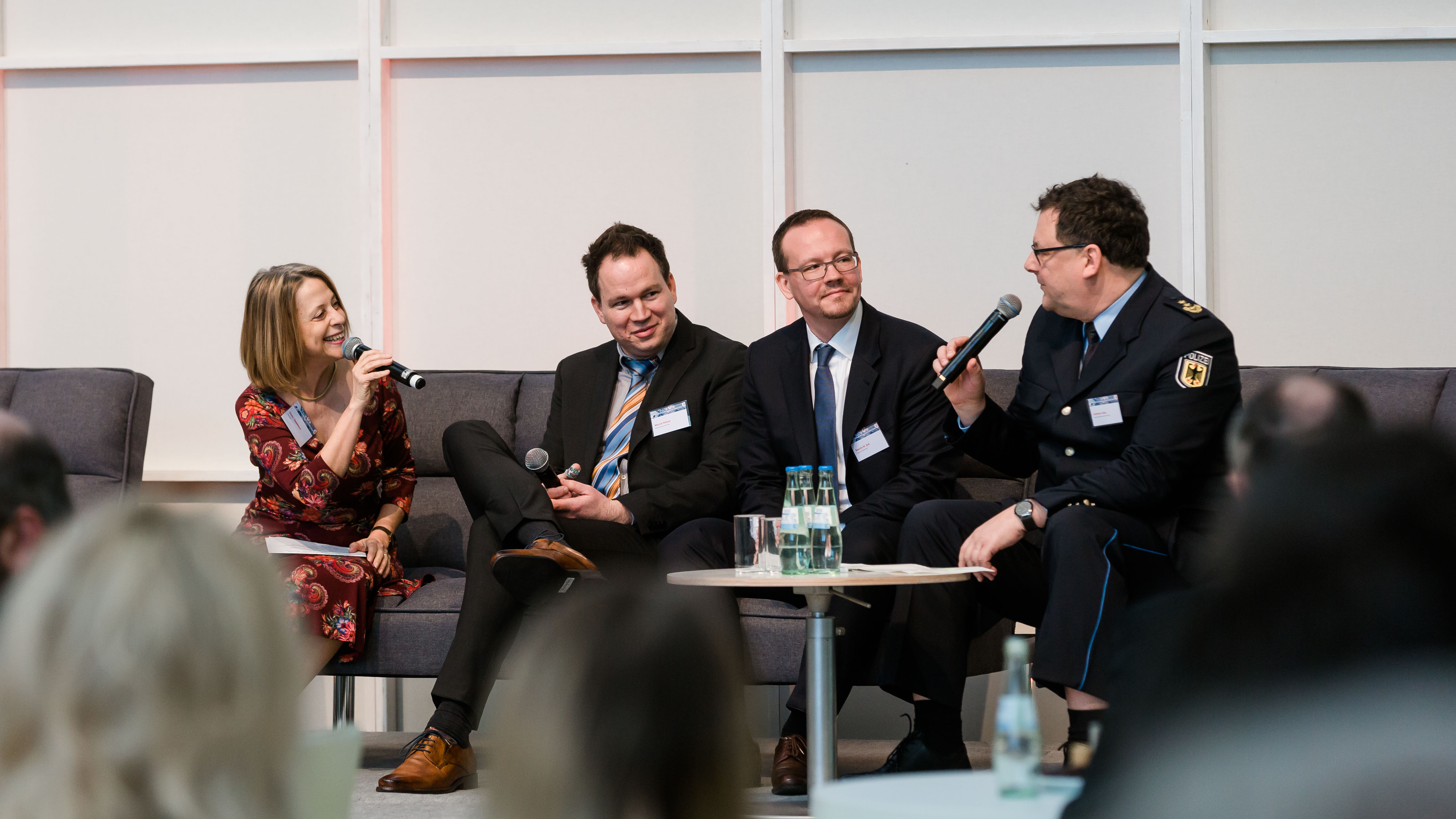 Teilnehmer einer Podiumsdiskussion reden miteinander auf der Bühne. - öffnet Bild in größerer Ansicht